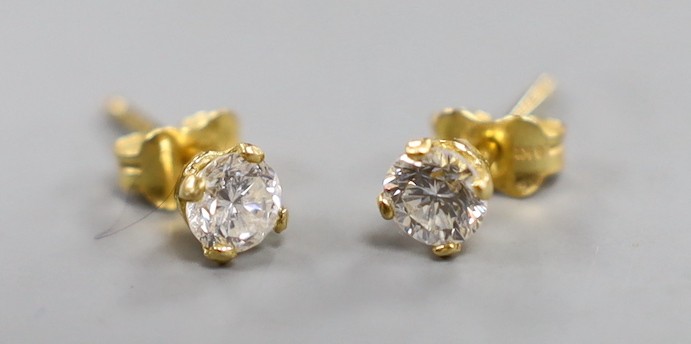 A pair of 18kt and solitaire diamond set ear studs, gross weight 1.2 grams.